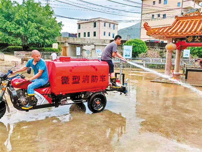 谷饶镇出动消防车清洗受灾路面。