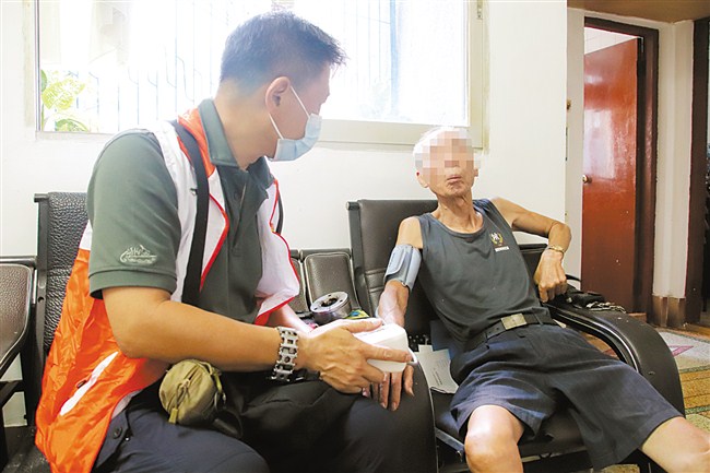 志愿者入户探访，为长者测量血压。