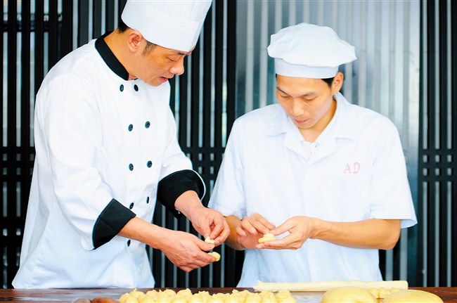 刘维雄（左）传授包酥技艺。